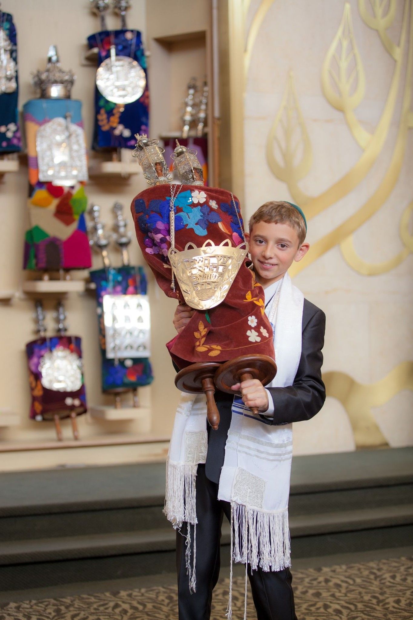 Bar mitzvah boy holding decorated Torah