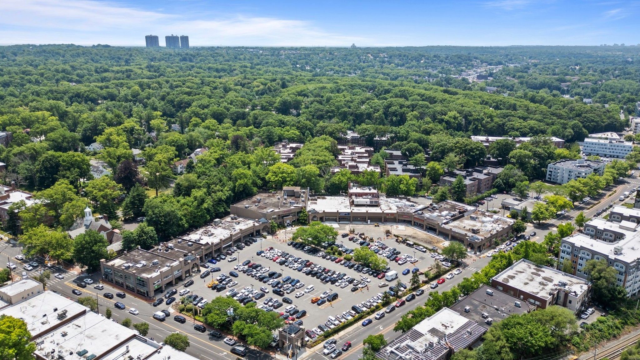 Aerial drone view of retail buildings and parking areas