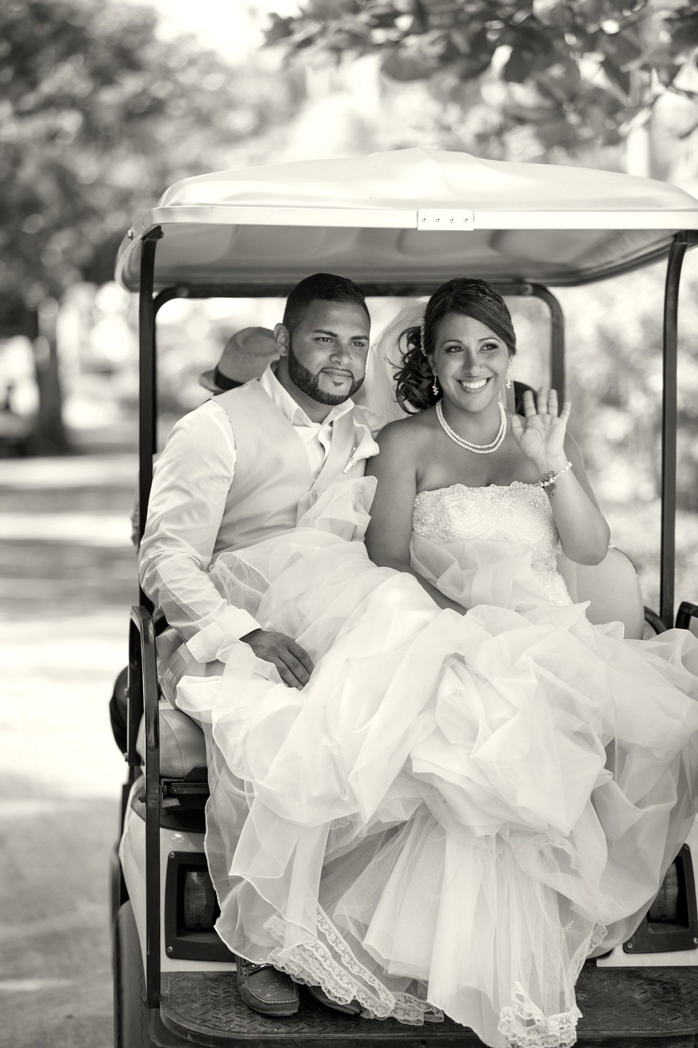 Newlyweds riding together in a wedding-day golf cart