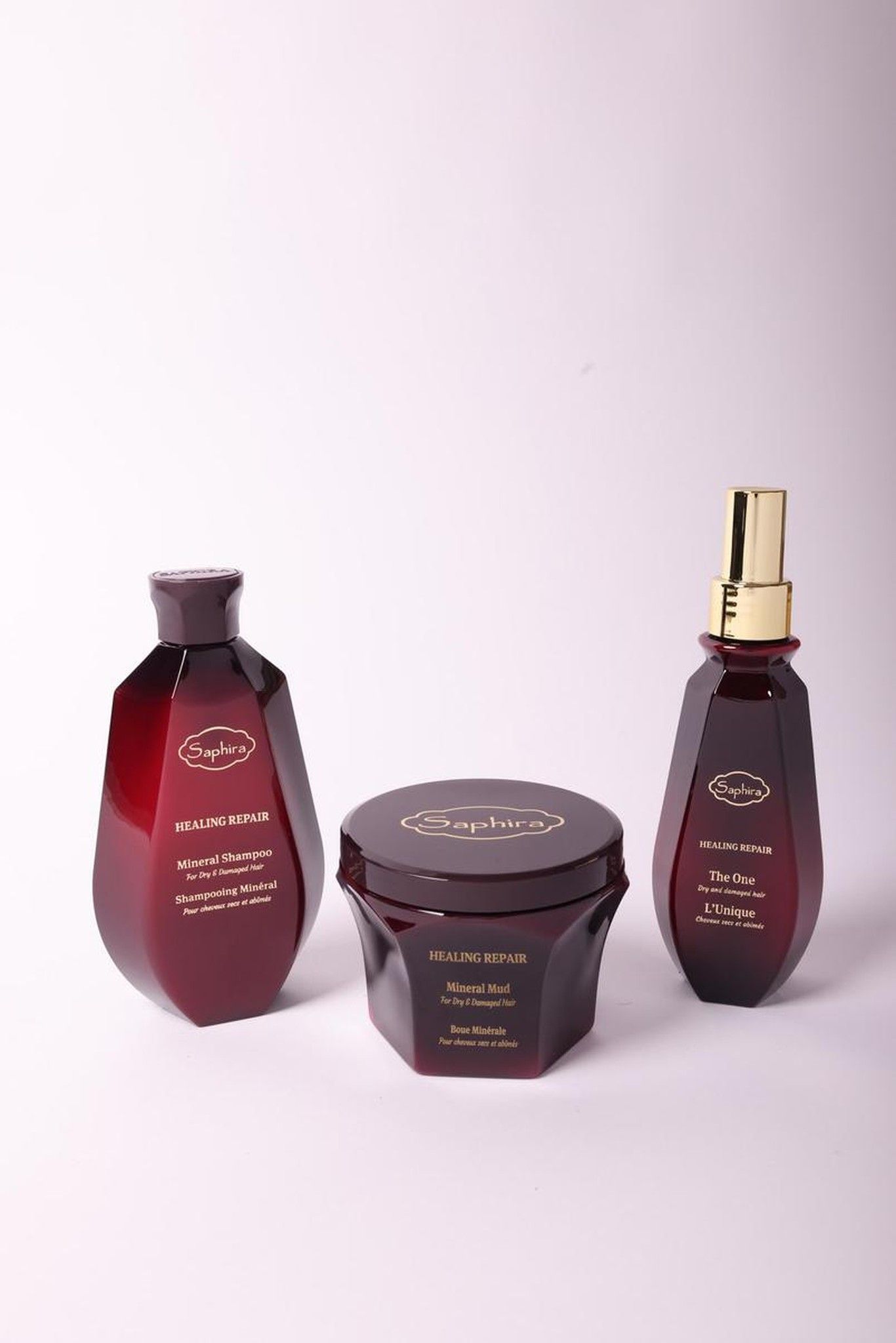 Saphira Healing Repair line: mineral shampoo, mineral mud, and The One spray on a light background