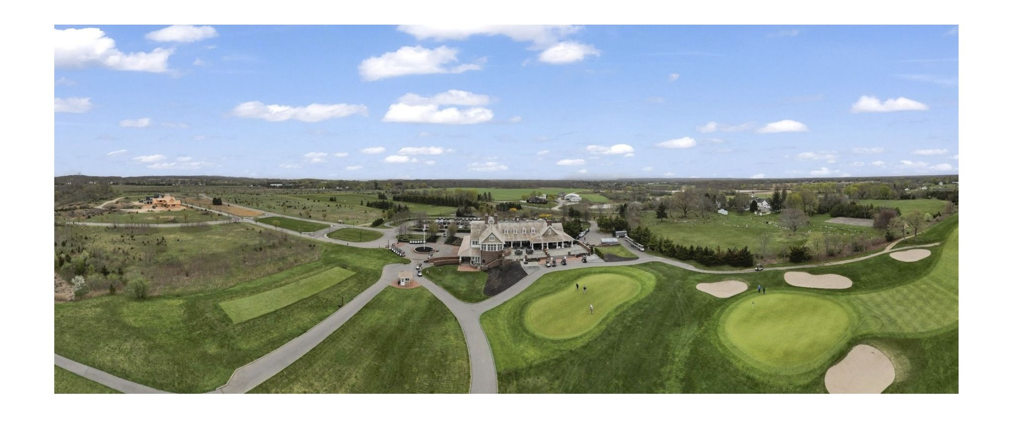 Aerial drone view of a golf course clubhouse and fairways