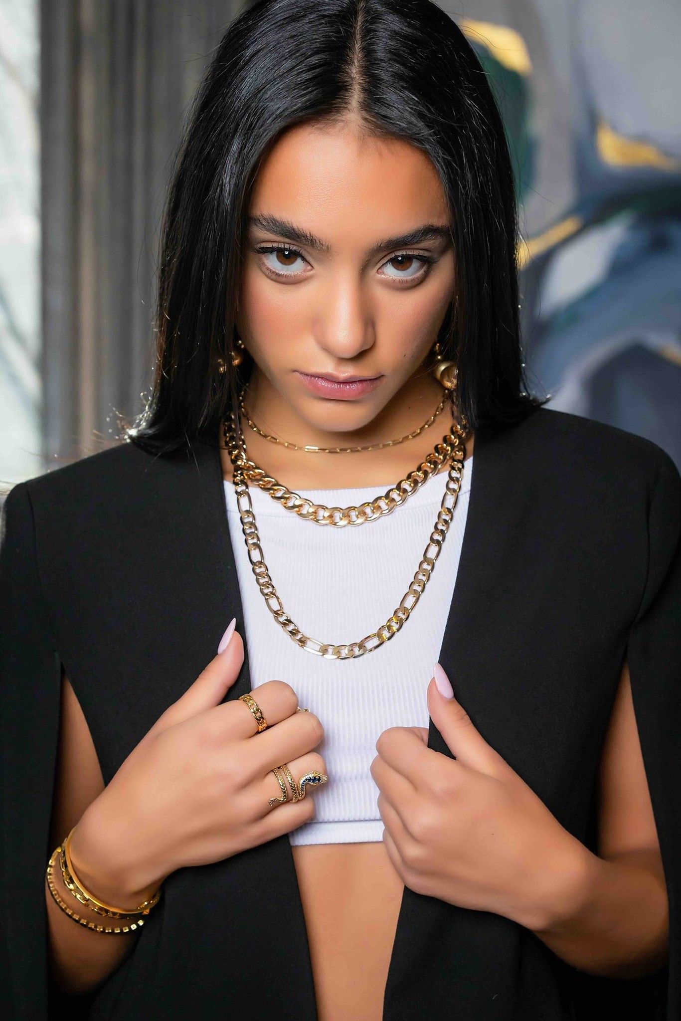 Model wearing layered gold necklaces