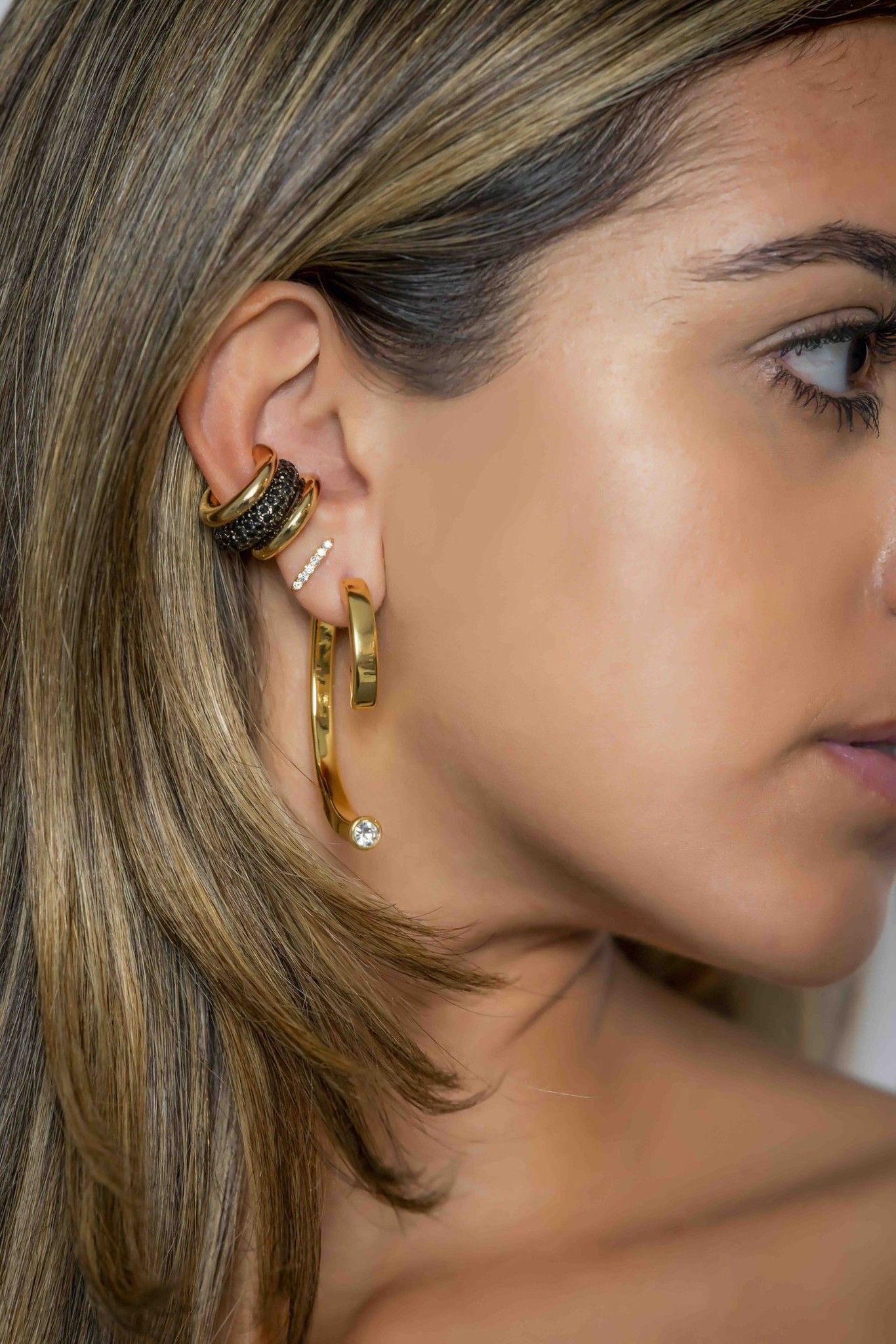 Side profile of model wearing gold hoop earrings