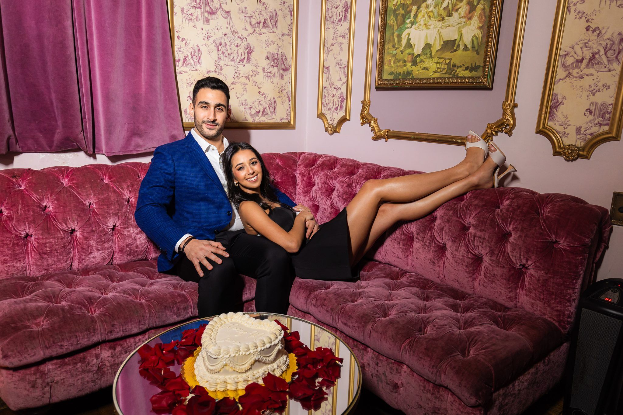 Couple on a pink couch with a heart cake